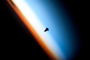 Слои атмосферы. Оранжевый — тропосфера, белесый — стратосфера, синий с переходом в черный — мезосфера. Видимый на снимке шаттл Endeavour находился еще выше